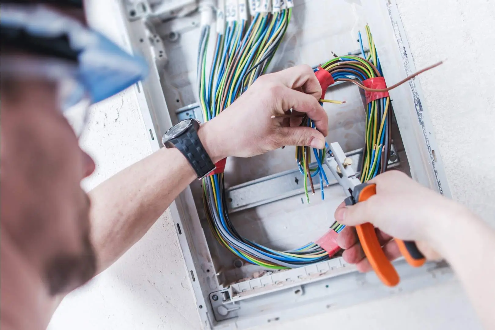 Electrician – North Sydney – worker connecting multiple coloured cables inside an electrical junction box.