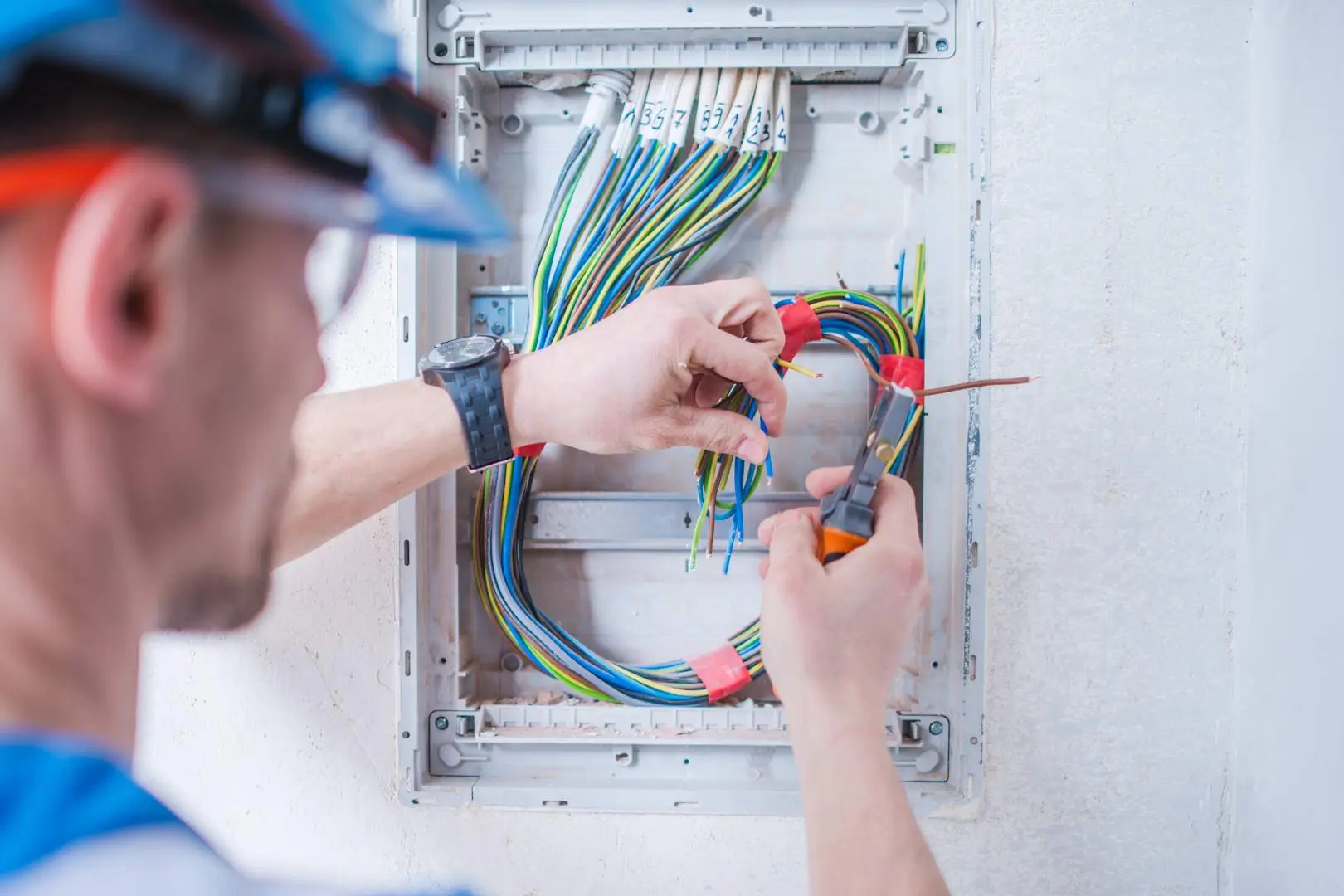 Electrician – Parramatta – Level 2 electrician organising and testing bundled cables within a residential switchboard.